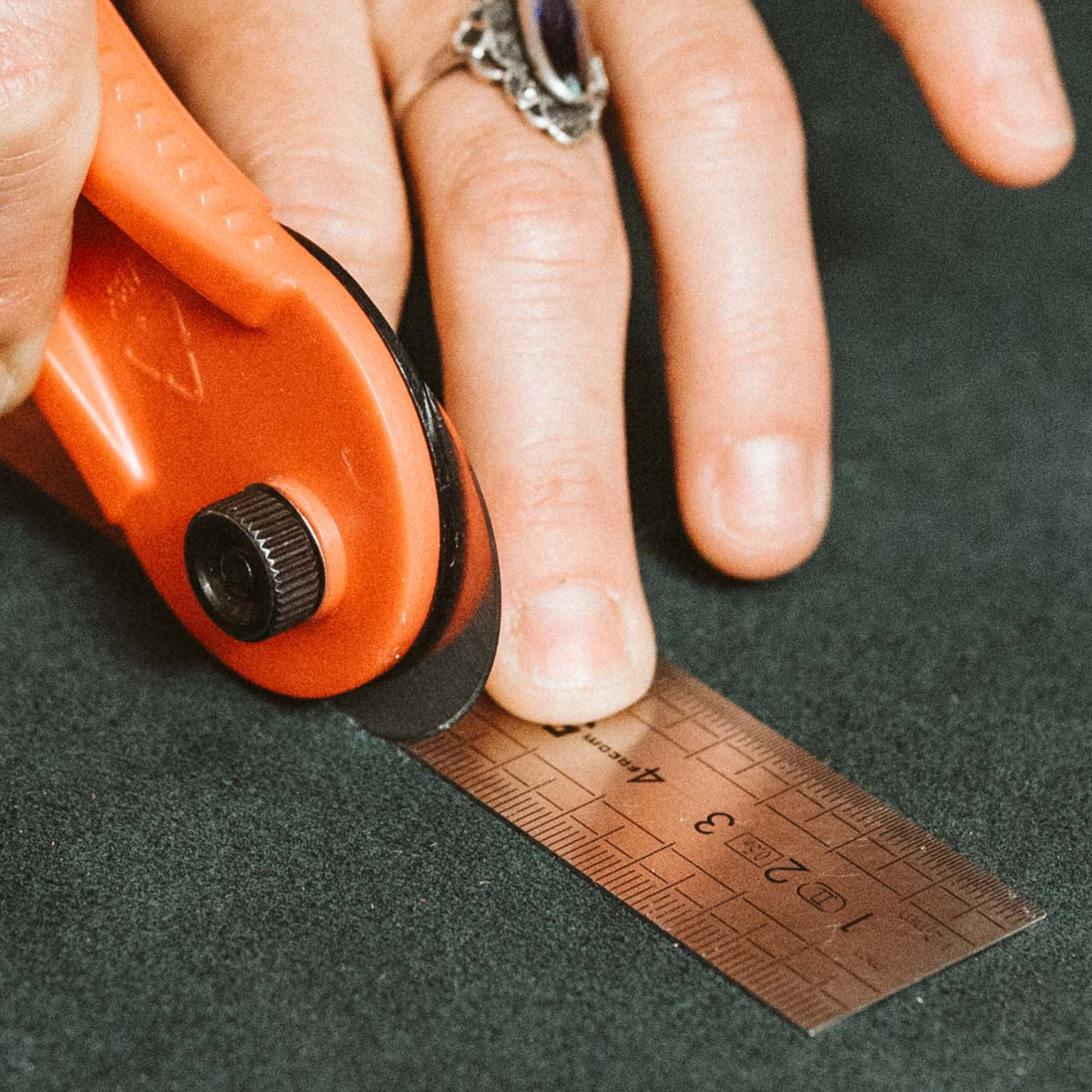 Artisan qui prend des mesures sur un morceau de cuir.